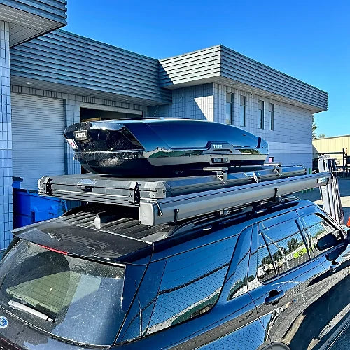 Black SUV with Thule cargo box mounted on aluminum roof bars for camping and long trips
