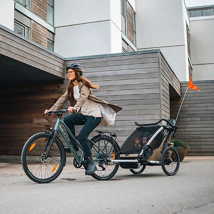 Thule Chariot Cross 2 Double Faded Khaki bike trailer in motion during family ride with children safely seated inside