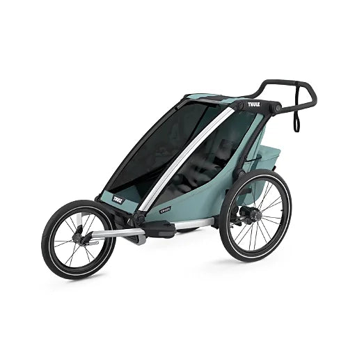 Thule Chariot Cross Single Alaska Blue attached to a bike tow arm, designed for active families who cycle with kids