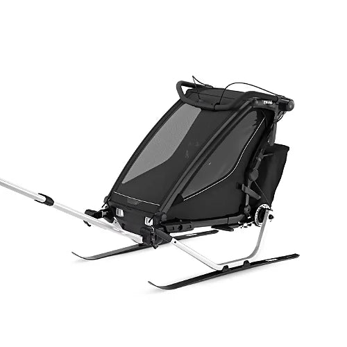 Thule Chariot Sport 2 with ski kit setup for winter activities showing dual skis and harness for all-season use