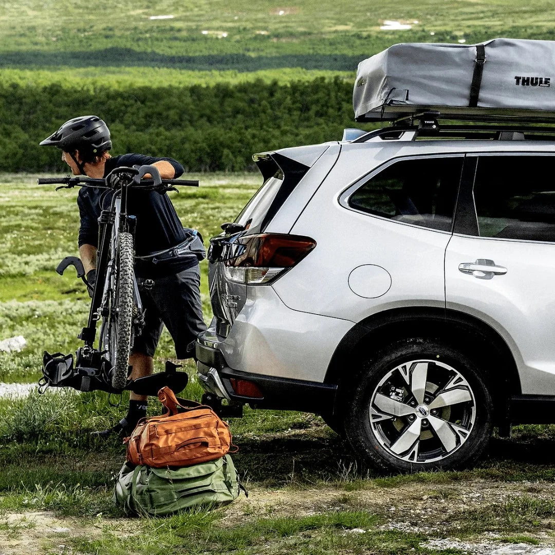 Thule DoubleTrack Pro holding one bike. Man takes bike off the rack 