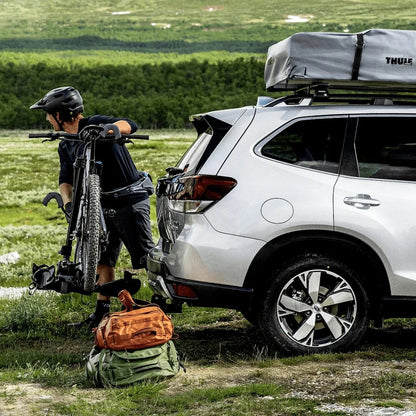 Thule DoubleTrack Pro holding one bike. Man takes bike off the rack 
