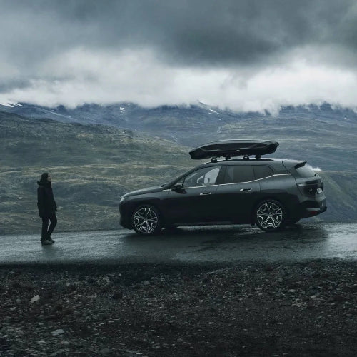 Thule Motion 3 roof box mounted on dark SUV parked in mountain landscape