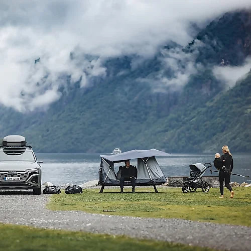 Thule Outset 3-person hitch-mounted car tent pitched by a scenic lakeside, offering elevated sleeping space