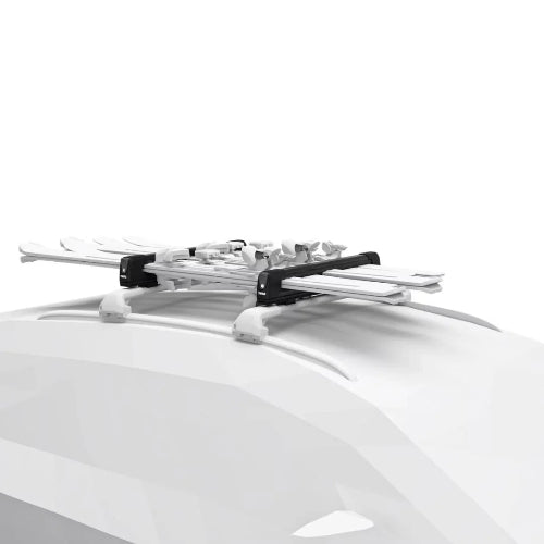 Thule SnowPack Extender mounted on car roof carrying multiple pairs of skis