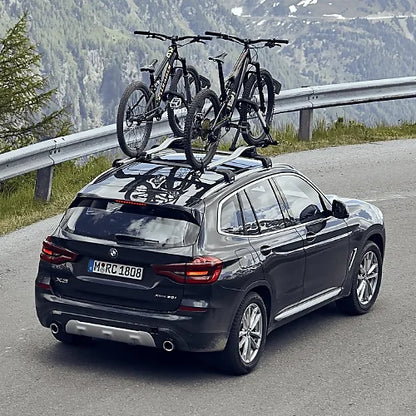 BMW X3 driving mountain road with two bikes mounted using Thule UpRide rack