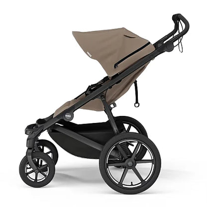Side view of Thule Urban Glide 4-wheel tinted taupe all-terrain stroller with large rear wheels and swivel front wheels
