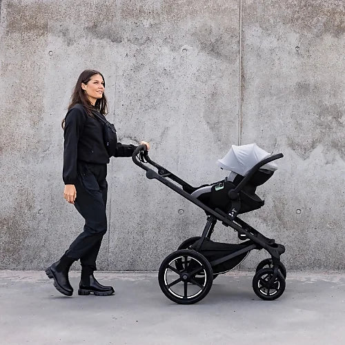 Thule Urban Glide 4-wheel stroller used as travel system with infant car seat adapter on city sidewalk