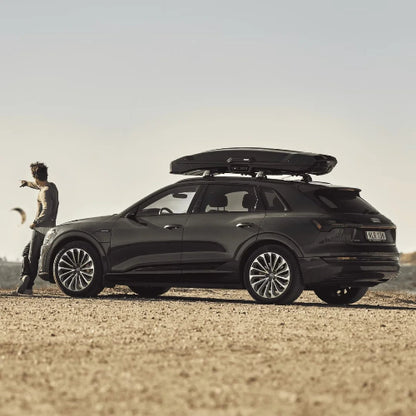 Thule Vector Alpine roof cargo box on SUV in outdoor setting demonstrating versatility for road trips and gear storage