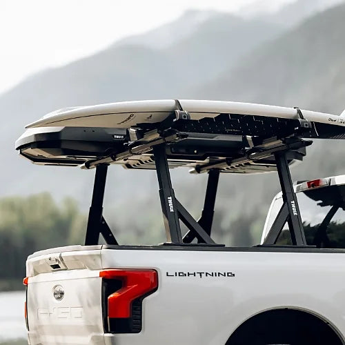 Close-up of Thule Xscape load bars supporting paddle boards on a pickup truck bed