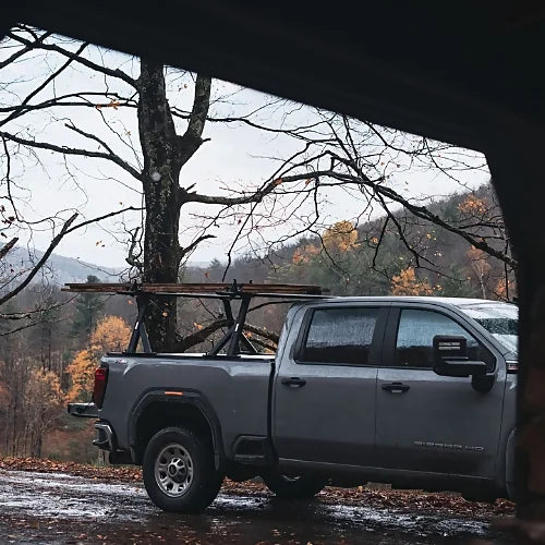 Thule Xscape SR baserail truck rack mounted on pickup truck carrying cargo in outdoor mountain environment