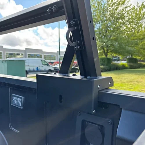 Close-up view of truck bed rack mounting bracket with matte black finish