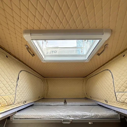 Interior view of truck camper showing skylight roof vent and insulated quilted walls