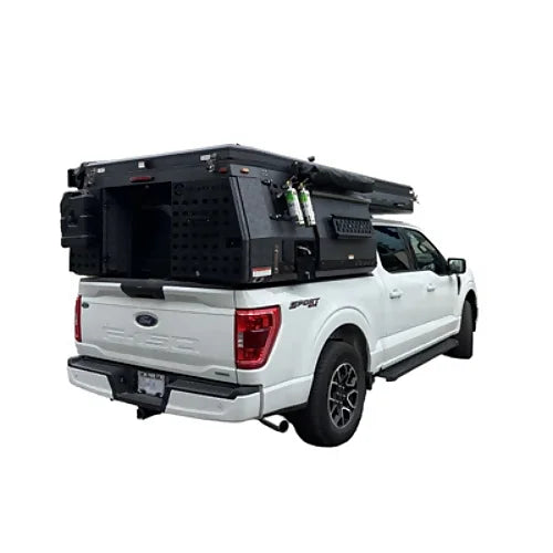 Rear three-quarter view of truck camper with roof closed and storage compartments visible