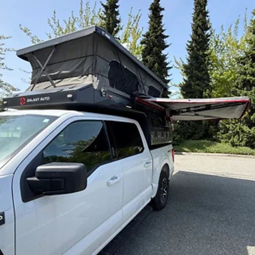 Truck camper with side awning extended for outdoor shade