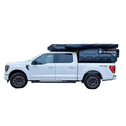 Side profile of pickup truck with camper roof closed for driving mode