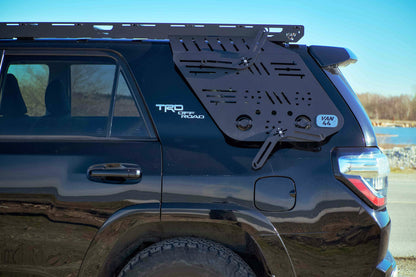 Black SUV with platform roof rack and TRD off-road badge on a clear day.