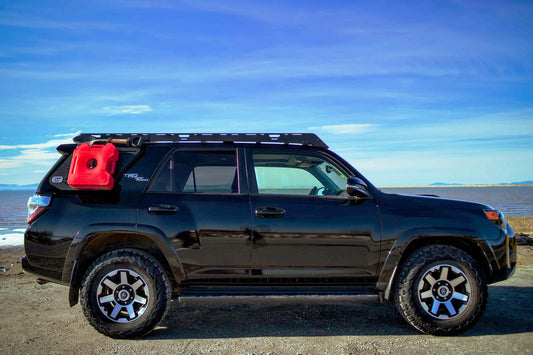 Black SUV with Van44 platform roof rack and red Gas cannister on beach