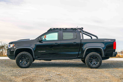 Black Chevrolet Colorado ZR2 truck with Van44 platform roof rack on a gravel surface