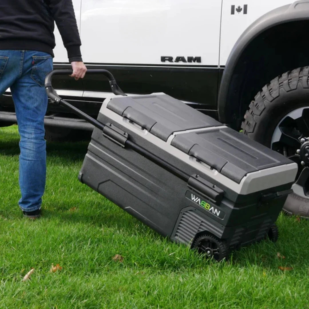 Man pulling Wabban fridge across grass by telescopic handle