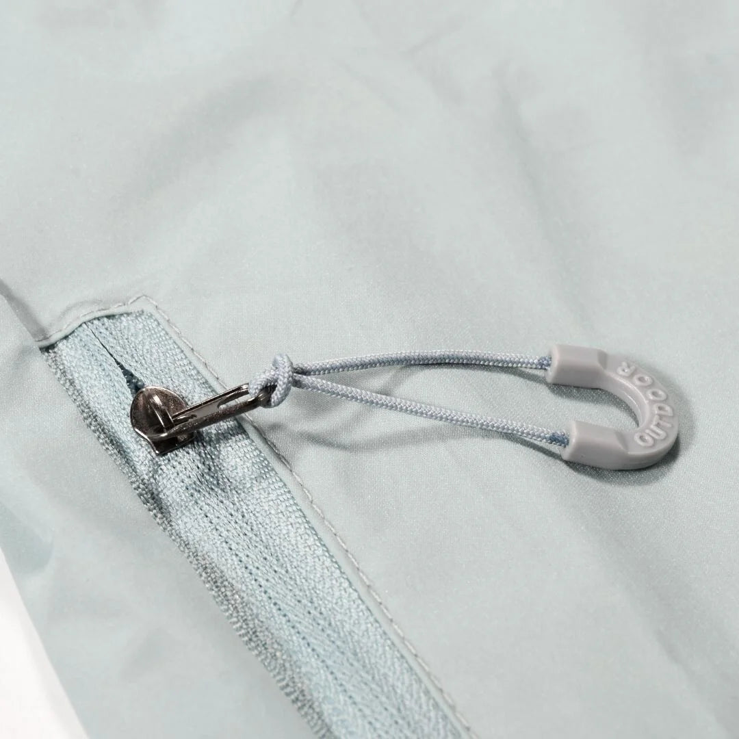 Close-up of light grey windbreaker drawstring and toggle detail
