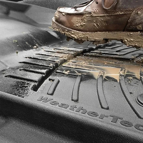 Mud-covered boot on WeatherTech FloorLiner showing deep channels for containment