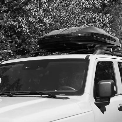 Woods black roof box mounted on SUV roof rack for extra cargo storage