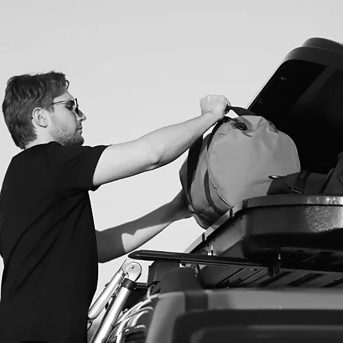 Woods Star roof cargo box being loaded with gear on a vehicle roof rack