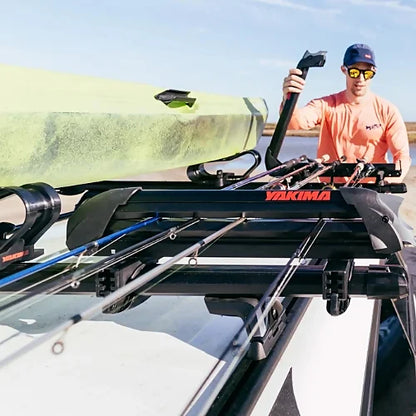 Angler loading fishing rods into Yakima ReelDeal rooftop rod rack using side-access clamp system