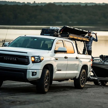 Yakima TopWater cargo box on white Toyota Tundra parked at boat launch with angler nearby