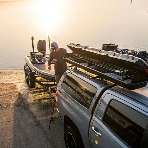 Angler setting up fishing rod near lake with Yakima TopWater box open on vehicle roof