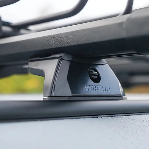 Yakima TrackTower base installed on vehicle track system supporting rooftop cargo basket