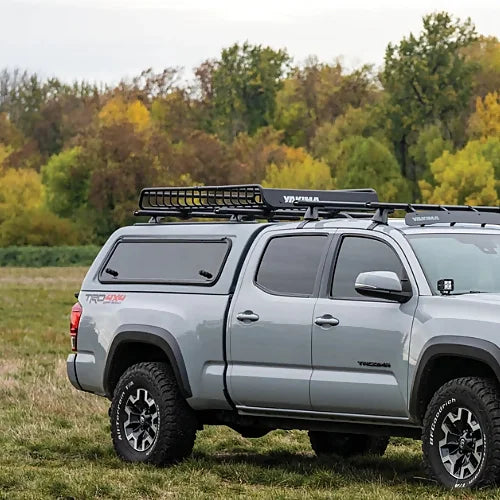 Toyota Tacoma equipped with Yakima TrackTower and rooftop cargo basket for overlanding and adventure setups